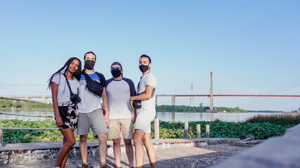 four friends posing in front of the bridge