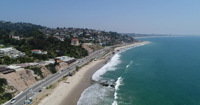 Drone shot what Big Dume Beach with town on the hill at California