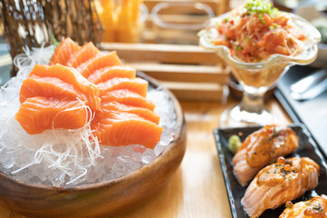 A set of sushi on a wooden table in a Japanese restaurant.Fresh salmon sliced for sushi menu.