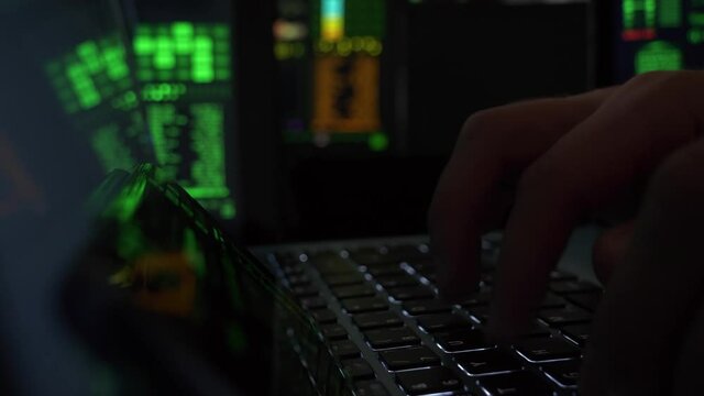 person typing in a technology center on a laptop, slider reveal close-up