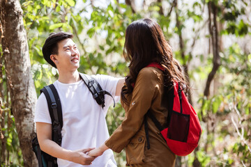 young asian man and woman couple with backpack travel in forest, couple travel concept.