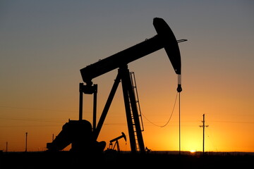 Pumpjacks, the sunset of New Mexico oil field, shot near Carlsbad. - obrazy, fototapety, plakaty