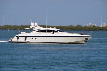 Fototapeta na wymiar Sleek white motor yacht cruising slowly on the Florida Intra-Coastal Waterway