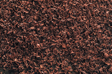 Grated dark chocolate. Chocolate flakes on brown table