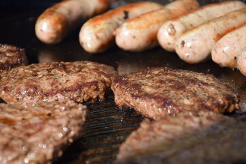 Sausages and steak cooking on a bbq