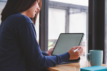 Beautiful asian woman using digital pen on tablet computer at modern office.