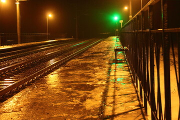 Railway station at night. Train platform in the fog. Railway
