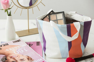 Bag with decorative cosmetics on table