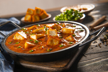 Mattar Paneer or cottage cheese with Peas. A vegetarian Indian delicacy, with raw peas and fried paneer (cottage cheese) in the background. 	