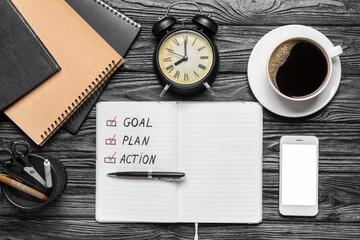 Text GOAL PLAN ACTION in notebook, mobile phone and cup of coffee on wooden background