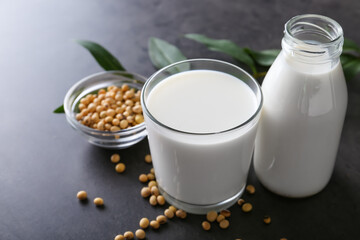 Glassware with tasty soy milk on dark background