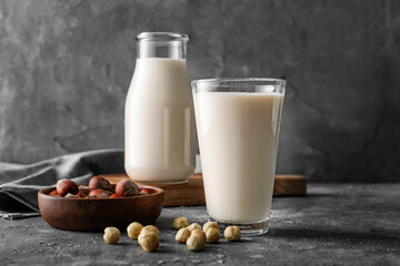 Glass of tasty hazelnut milk on dark background
