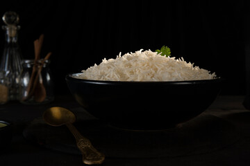 Steamed rice in a black bowl with green chutney and curd	