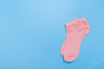 pink new socks stacked on a blue background. top view.