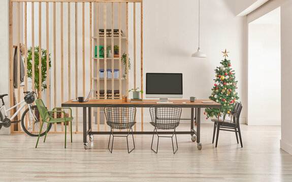 Modern and decorative office interior style with wooden long table, black metal chair, computer and laptop style.