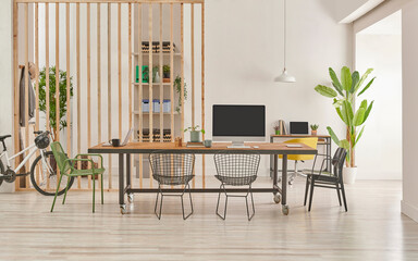 Modern and decorative office interior style with wooden long table, black metal chair, computer and laptop style.