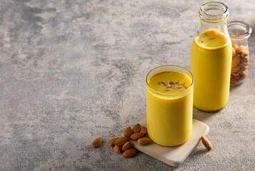 A glass and a bottle  of healthy  turmeric milk with almonds	