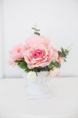 Round elegant vase with artificial roses. Beautiful elegant gift
