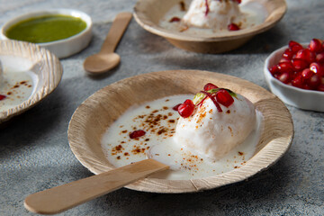 Dahi Vada or Dahi Bhalla are fried lentil dumplings, topped with curd, sweet and green chutney and spices	