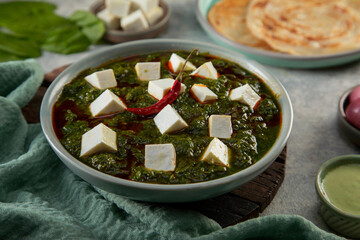 A BOWL OF GARNISHED PALAK PANEER KEPT ON TABLE	