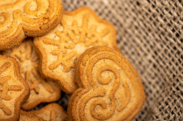 Delicious homemade cookies on a wooden table on a homespun fabric with a rough texture. Close-up selective focus.