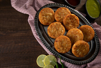 CRISPY ALOO TIKKIS KEPT ALONG WITH CHUTNEY ON TABLE	