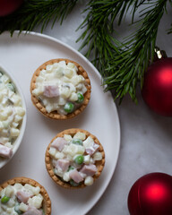 Traditional Russian salad Olivier in tartlets and Christmas decorations