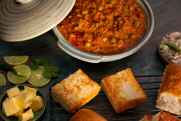 DELICIOUS BHAJI CURRY WITH GRILLED PAV KEPT ON TABLE	