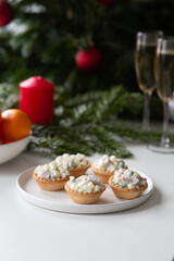 Fototapeta na wymiar Traditional Russian salad Olivier in tartlets and Christmas decorations