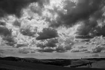 Dramatic clouds over an expansive landscape in black and white