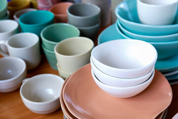 Close up of empty ceramic bowls and plates on wooden table in market