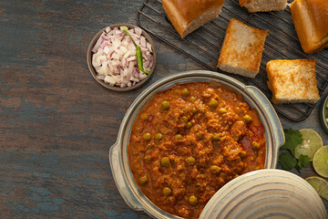 DELICIOUS BHAJI CURRY SERVED IN BOWL KEPT ALONG WITH CRISPY PAVS	