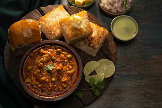 DELICIOUS PAV BHAJI SERVED WITH APPETIZERS ON A WOODEN TRAY	
