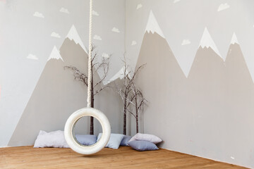 Playing room for a boy. Stylish kid room with illustration of mountains and bungee/swing. Mountains illustration in a child room