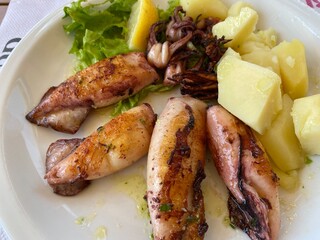 gegrillte Calamari Tintenfische in Knoblauchöl mit Salzkartoffeln Salat und Zitrone