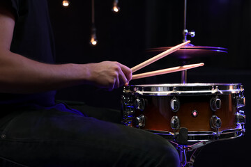 Drummer playing snare drum with sticks close up.