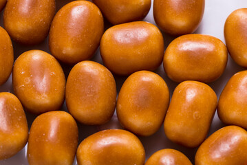 Fototapeta premium Lot of brown sweet candy, colored background