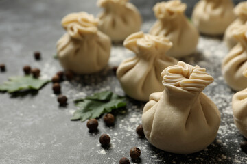 Khinkali, spices and flour on black smokey background