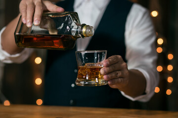 Fototapeta na wymiar Barman pouring whiskey whiskey glass beautiful night
