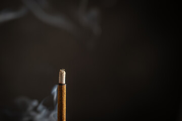 Asian incense stick burning with smoke, close up, macro