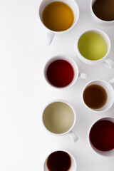 Different types of tea for ceremony. Set of cups with tea. White cups with different types of tea on a white background.