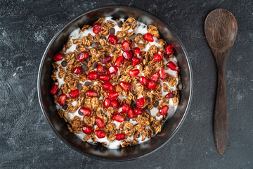 Granola with oatmeal, dried fruit, honey, raisins, chocolate chips, nuts and red pomegranate seeds with yogurt