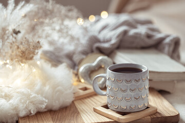 Home composition with beautiful cup on blurred cozy background.