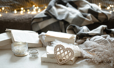 Cozy home composition with decorative wooden heart and books and decor details.