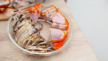 A cold plate prepared for the party with sliced ham and sausages, a set of cold cuts
