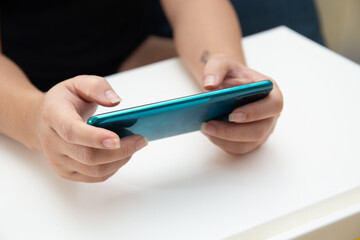 Close up shot of female using smart phone for playing online mobile game 