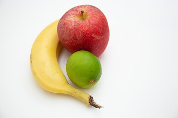 Close up shot of banana , apple and lemon isolated on white background