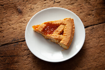 apricot tart slice on saucer, over wooden table