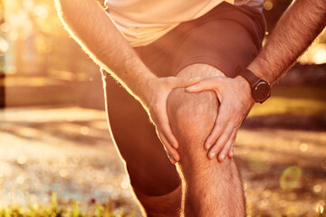 Sports jogging running injury in the park, young man having knee pain problem.