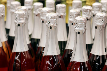 Sparkling wine bottles in a supermarket. Champagne in wine store, alcohol industry